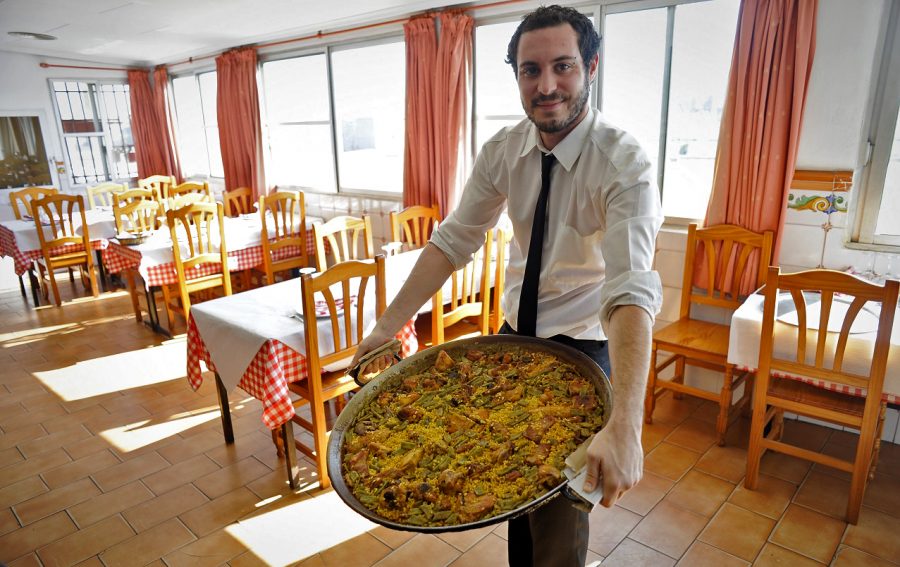 A waiter transporting his huge pan of paella