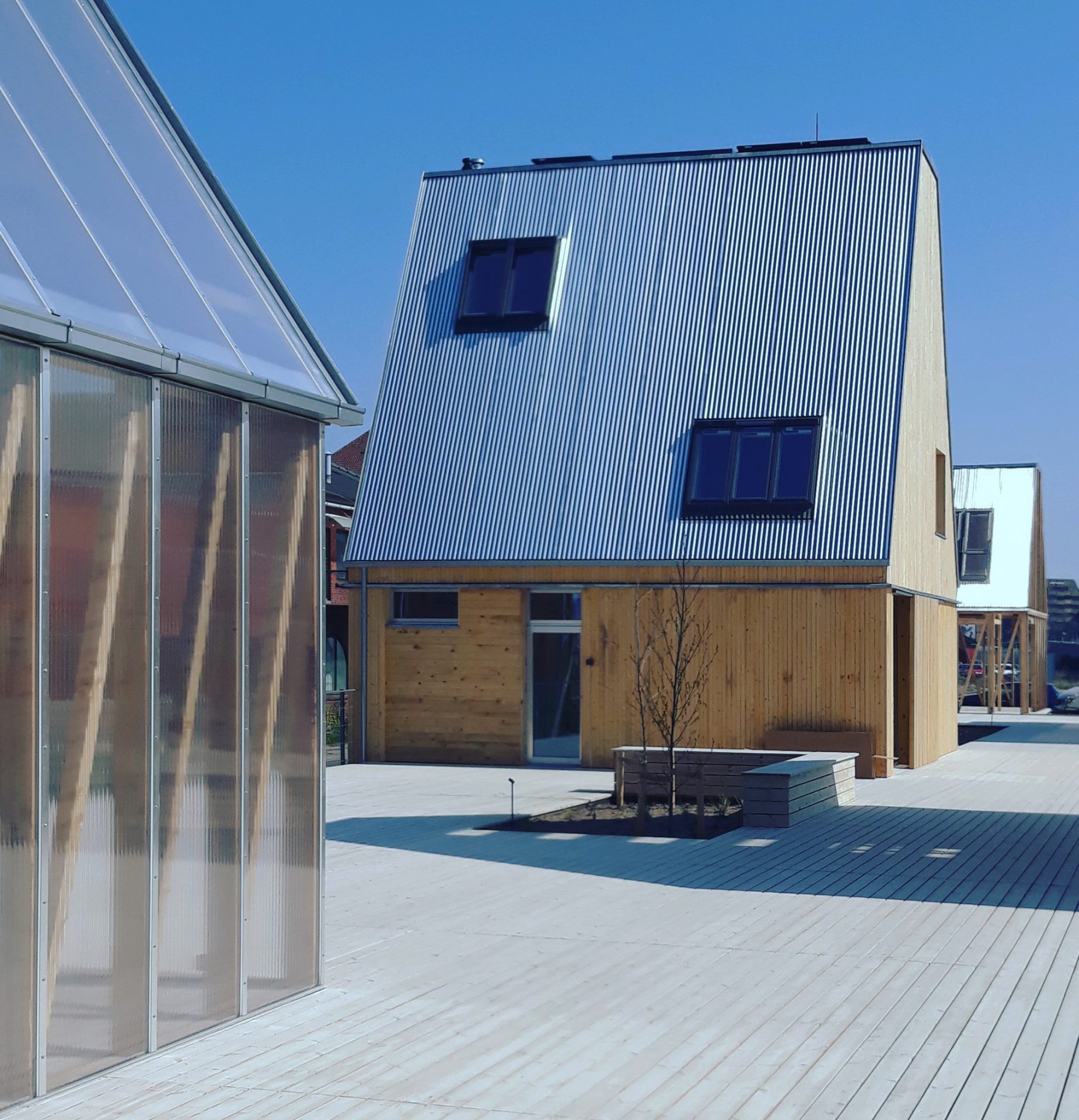 A wooden single-family home with a tall, pitched roof and ultra-low carbon footprint. Photo by: ©Bo Christiansen